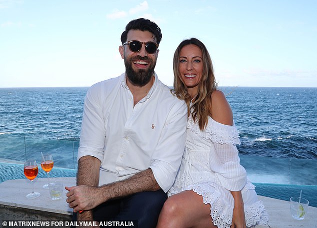 A couple enjoy drinks by the sea at a stunning mansion in Sydney on New Year's Day