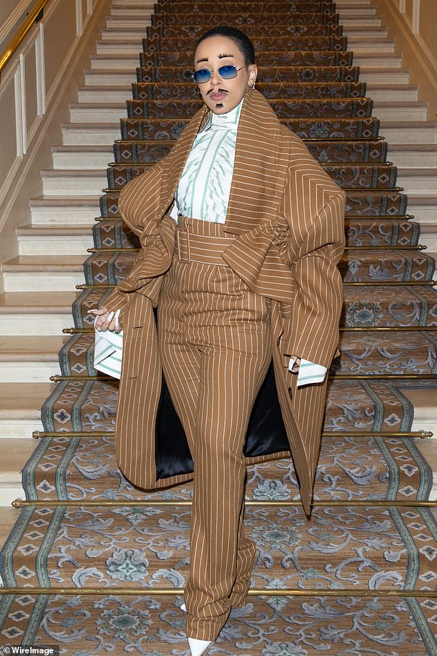 Go this route: Doja turned heads with her quirky androgynous look as she emerged in high-waisted pinstriped trousers and a matching oversized coat that swamped her slim figure