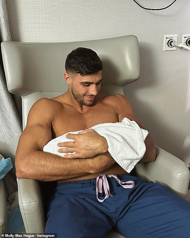 Dad in love: Another photo showed the shirtless boxer, also 23, holding his daughter in the hospital