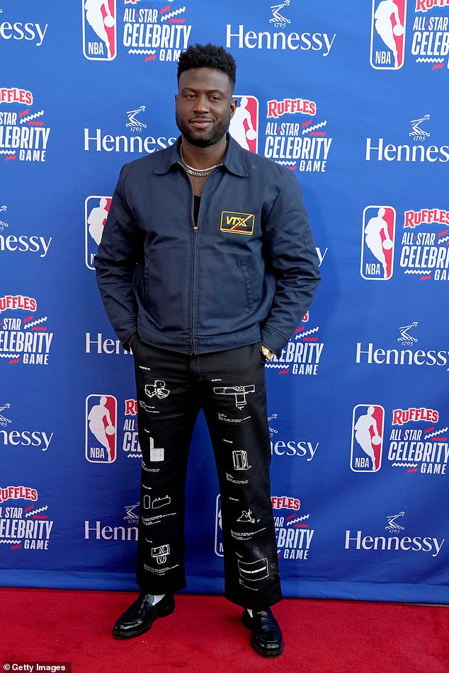 Sinqua Wells, 37, wore a navy blue jacket and black trousers covered in minimalist white drawings