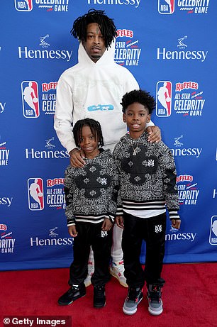 Family affair: 21 Savage hit the red carpet in a white sweater with his two guests, who could be his sons