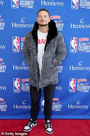 Country star: Country singer Kane Brown wore a dark gray jacket with brown fringes and a white shirt with red lettering