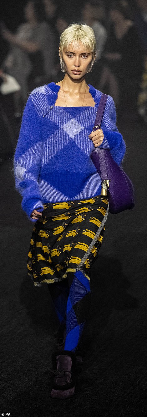 Accessories: She carried a bold purple handbag and donned gold jewelry