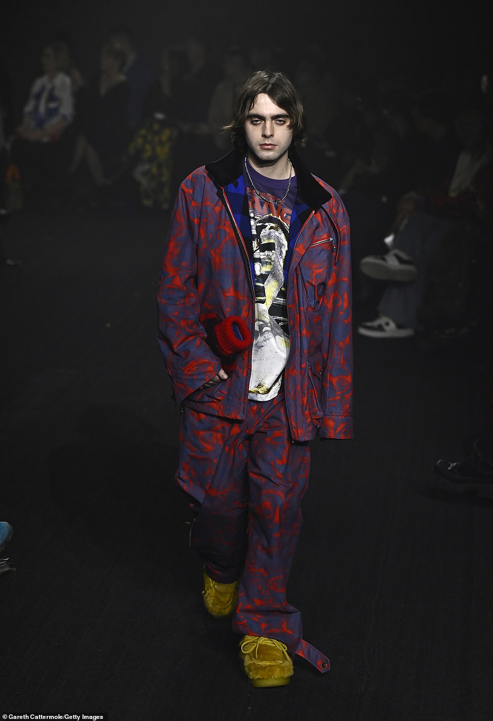 Bold: Lennon Gallagher showed off his quirky style in a red and blue jacket and trousers paired with mustard yellow slip-on shoes as he walked the runway